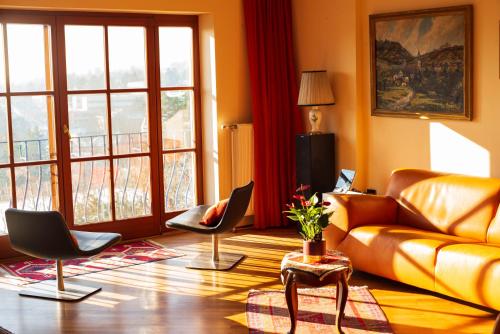 ein Wohnzimmer mit einem Sofa und Stühlen in der Unterkunft Herrlicher Ausblick über Wien in Wien
