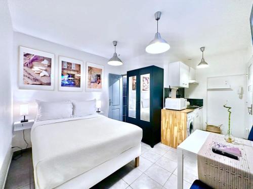 um quarto com uma cama branca e uma cozinha em Èrsextius MMC Aix-en-Provence em Aix-en-Provence