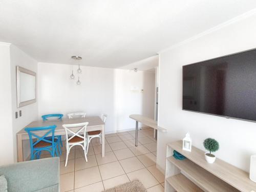 a living room with a dining room table and a tv at Departamento totalmente equipado a pasos de la Playa y Casino Enjoy in Coquimbo