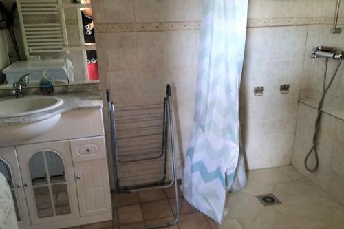 y baño con ducha, lavabo y cortina de ducha. en studio rez-de-chaussée jusqu'à 4 personnes, en Joué-lès-Tours
