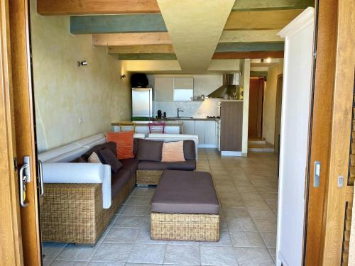 Una sala de estar con un sofá y una cocina. en Punta Est Trilocale Stupenda Vista Mare, en Capo Coda Cavallo