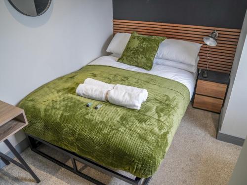 a bedroom with a bed with two towels on it at Sophisticated private getaway Pass the Keys in Beeston
