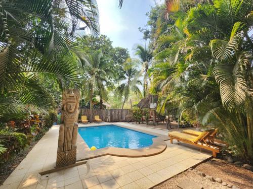 a swimming pool in a yard with palm trees at Villas Pura Vibra in Potrero