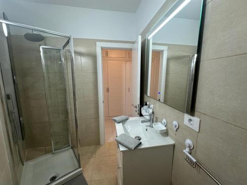 een badkamer met een douche, een wastafel en een spiegel bij Liwia beautiful apartment in the first Oceanline in Los Cristianos. in Los Cristianos