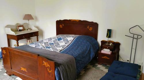 um quarto com uma cama com um edredão azul em Gîte de la rivière em Pineuilh