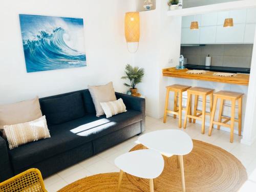 a living room with a couch and a kitchen at Apartamento Aqua Clara in Puerto del Carmen