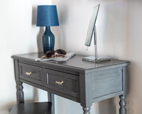 a gray desk with a lamp and a blue lampuanauanauanauanauana at Honey Pot, Chipping Campden, parking, garden, late check-out in Chipping Campden