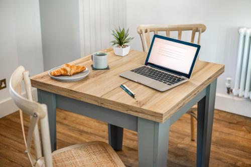 a laptop computer sitting on top of a wooden table at Honey Pot, Chipping Campden, parking, garden, late check-out in Chipping Campden