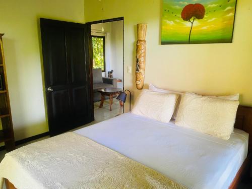 a bedroom with a white bed and a desk at Villas en el Bosque in Ojochal