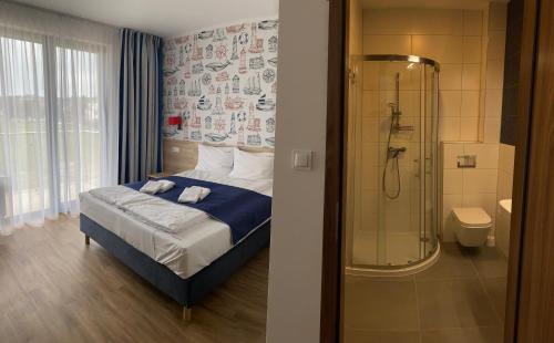 1 dormitorio con ducha, 1 cama y baño en Faro Resort, en Mrzeżyno