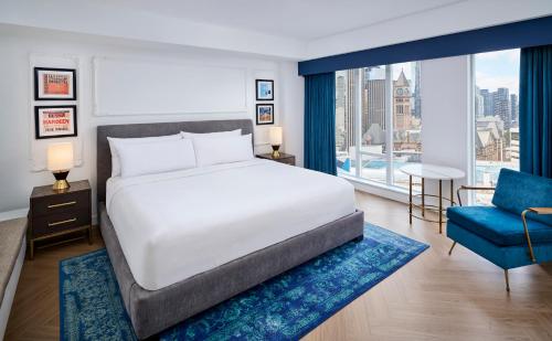 a bedroom with a large bed and a blue chair at Pantages Hotel Toronto Centre in Toronto