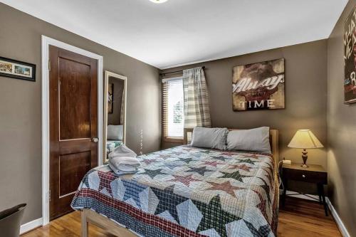 a bedroom with a bed with a quilt on it at Gorgeous 2 Queen Bedroom Apartment in North Buffalo with 70 inch TV in Buffalo