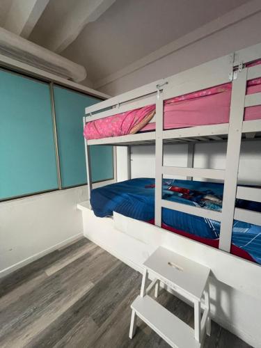 une chambre avec deux lits superposés et un bureau dans l'établissement Appartement lumineux - 7 personnes - Falaises - Port - Parking, au Cap d'Agde
