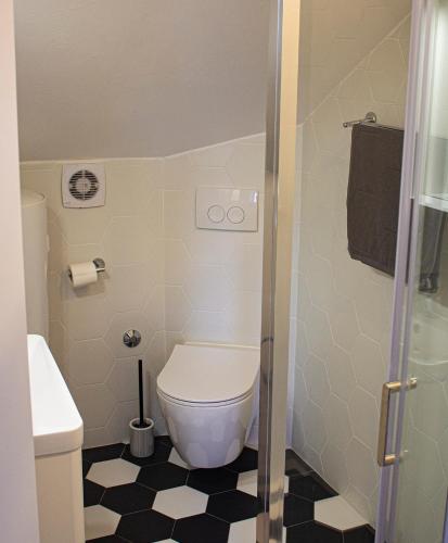 a bathroom with a toilet and a black and white floor at Lemon&Stone in Korčula
