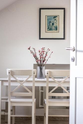 a dining room table with two chairs and a vase with flowers at Lemon&Stone in Korčula