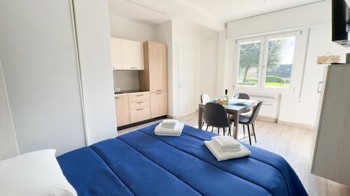 a bedroom with a blue bed and a dining room at Onda Blu House by Ca-Sa Check in Chioggia
