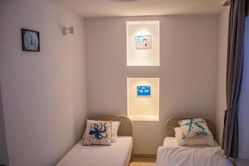 a room with two chairs and two paintings on the wall at Lemon&Stone in Korčula