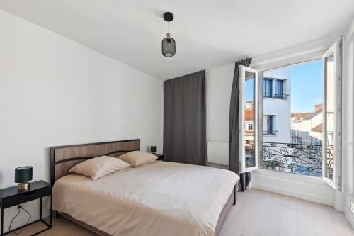 ein weißes Schlafzimmer mit einem Bett und einem großen Fenster in der Unterkunft Charmant T2 - Coeur d'Arpajon in Arpajon