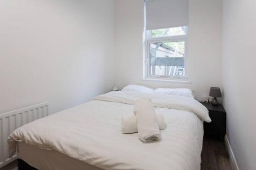 a white bedroom with a bed with towels on it at Boutique Apt in Belfast in Belfast