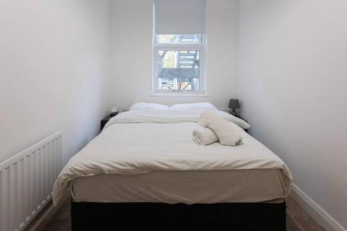 a bed in a white room with a window at Boutique Apt in Belfast in Belfast