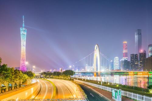 um horizonte da cidade à noite com uma ponte e edifícios em Wind sleeping Color Hotel - GuangZhou CHIME LONG Line7&18Nancun Wanbo STN em Guangzhou
