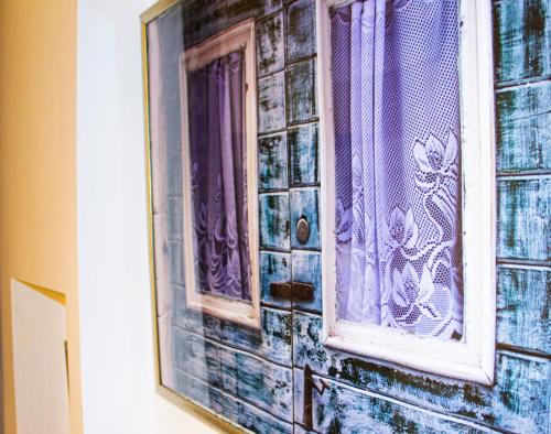 a window with purple curtains on a brick wall at Lemon&Stone in Korčula