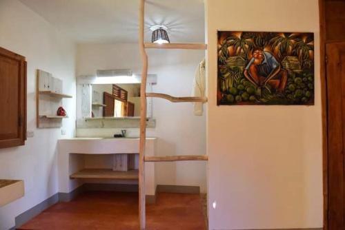 a kitchen with a painting on the wall and a spiral staircase at Eve Getaway in Madama