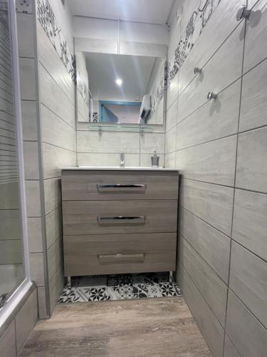 une salle de bain avec un lavabo et un miroir dans l'établissement Appartement lumineux - 7 personnes - Falaises - Port - Parking, au Cap d'Agde