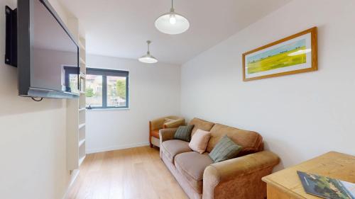 a living room with a couch and a television at Pitts Cottage Annexe in Bladon