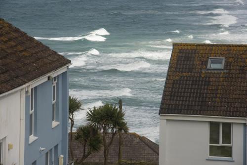 a view of the ocean from between two houses at 6 The Point, Newquay in Newquay