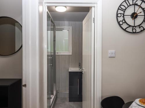 a bathroom with a mirror and a clock on the wall at 15 The Park in Bude