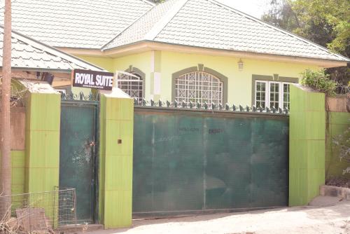 a house with a green gate in front of it at Royal suites and Apartments in Zaria