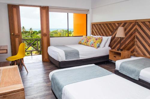 a hotel room with two beds and a balcony at Sol Caribe Campo All Inclusive in San Andrés