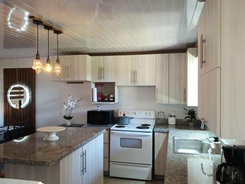 a kitchen with a white stove and a sink at Ledy's Inn in Turrialba