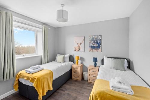 een slaapkamer met 2 bedden en een raam bij K Suites - Riding Leaze in Avonmouth