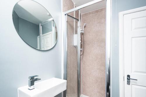 uma casa de banho com um lavatório e um espelho em K Suites - Riding Leaze em Avonmouth