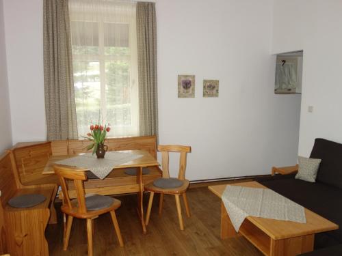 a living room with a table and a couch at MINERVA in Špindlerův Mlýn