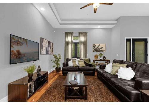 a living room with a leather couch and a table at Your Summer Getaway Awaits - Townhome by Disney! in Orlando