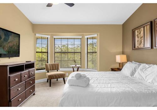 a bedroom with a bed and a tv and windows at Your Summer Getaway Awaits - Townhome by Disney! in Orlando