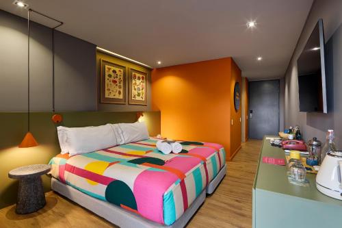 una camera con un grande letto e un bancone di Versus Hotel a Medellín