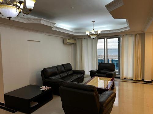 a living room with a couch and chairs and a table at Chantel Sea View in Dar es Salaam