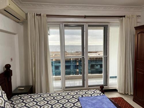 a bedroom with a large window with a view at Chantel Sea View in Dar es Salaam