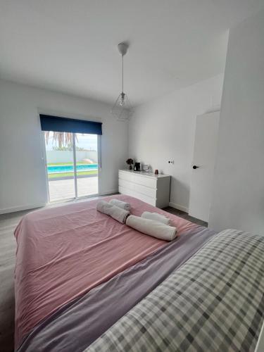 Cette chambre blanche dispose d'un grand lit et d'une fenêtre. dans l'établissement Casa Mayra, à Los Caparroses