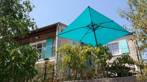 a blue umbrella hanging from a fence in front of a building at Villa Lamoureuse in Manosque