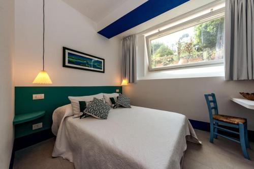 una camera da letto con un letto, una finestra e un tavolo di Casa La Scaletta, Capri a Capri