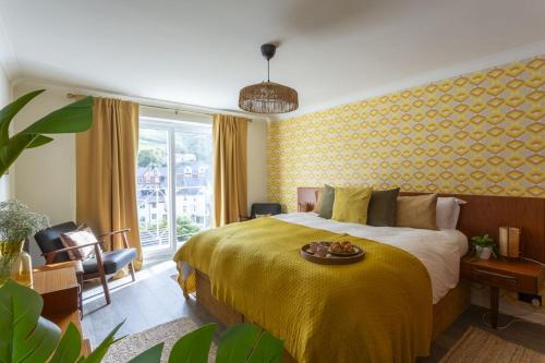 um quarto com uma cama grande e um cobertor amarelo em Harbour Lights em Dartmouth