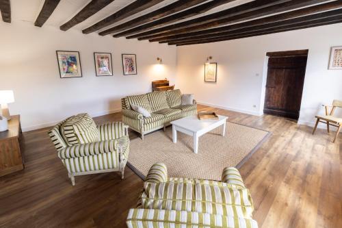 a living room with two chairs and a table at Maison de campagne in Archignat