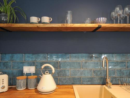 a kitchen counter with a tea kettle on a sink at The Bower in Helston