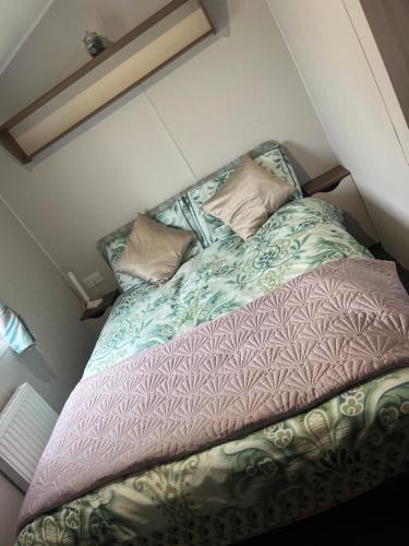 a bed in a small room with two pillows on it at Seton sands caravan rental in Port Seton