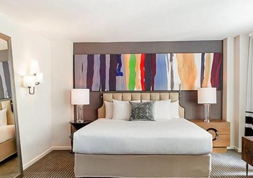 een slaapkamer met een groot bed en een schilderij erboven bij Lovely1BR Apartment in Midtown in New York